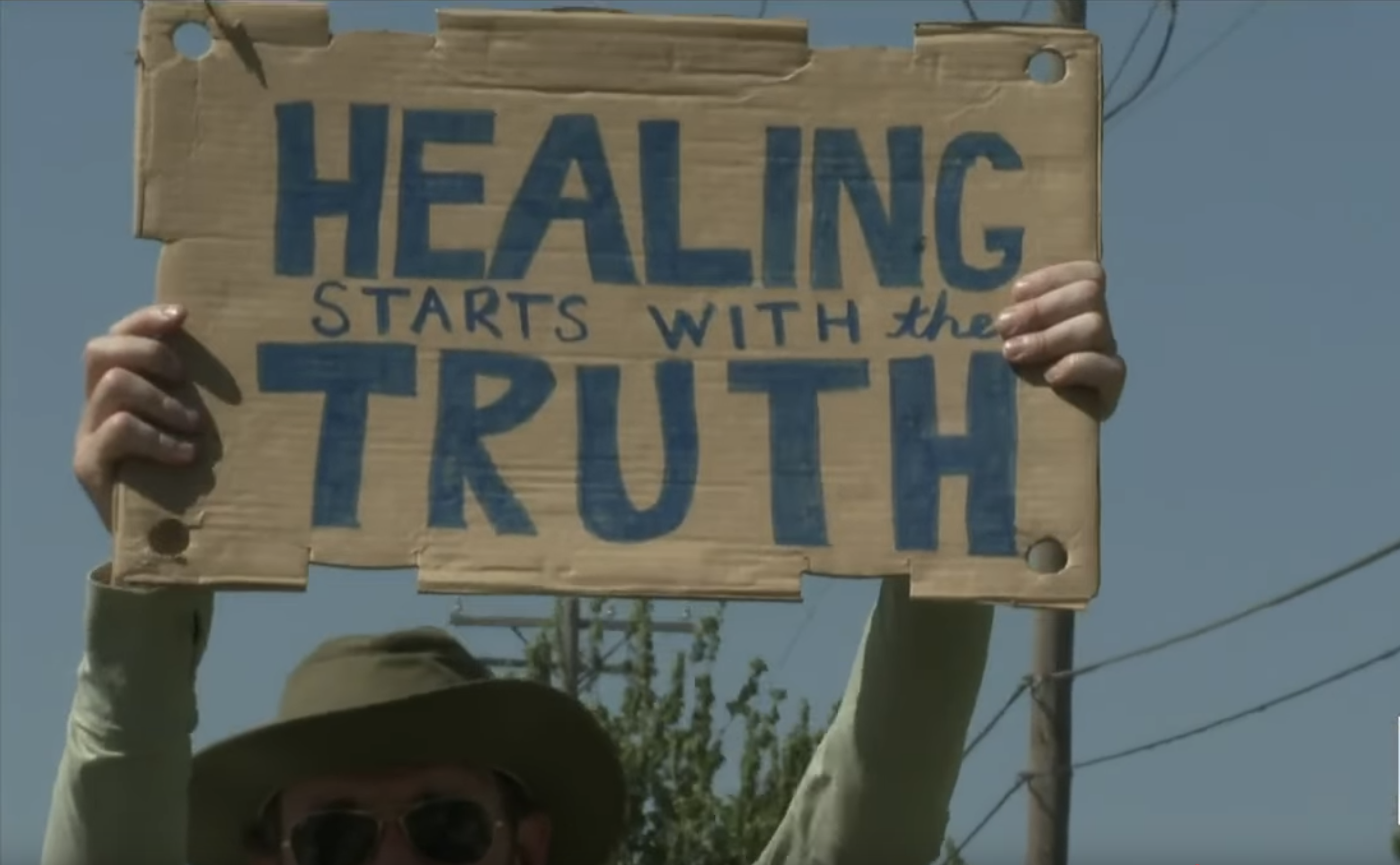 Protesters holding signs outside Eastminster Presbyterian Church demanding transparency and justice for abuse survivors